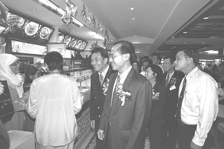 Guest of honour Minister for Information and the Arts and Second Minister for Trade and Industry Brigadier-General George Yeo Yong-Boon (centre) accompanied by Managing Director of Wah Khiaw Developments Private Limited Tan Seng Ong (on Minister's right) touring China Square Food Centre after its official opening 