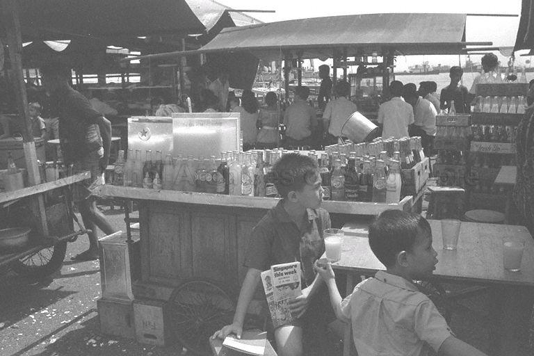 Children patronising a drink stall at Clifford Pier carpark, which turns into a hawker centre in the evenings. The hawkers later moved to Shenton Way, outside the Singapore Polytechnic's former campus.
