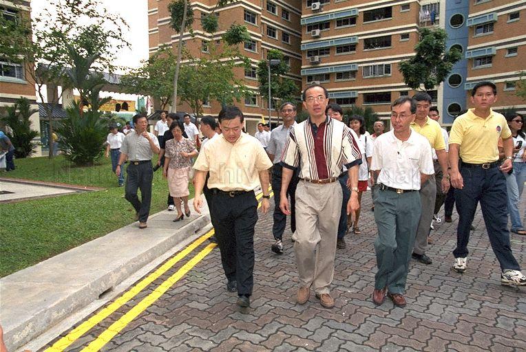 Minister for Information and the Arts and Second Minister for Trade and Industry Brigadier-General George Yeo Yong-Boon (in striped maroon polo shirt) and Member of Parliament for Tampines Group Representation Constituency Sin Boon Ann (left) during Minister's community visit to Tampines Central Division of Tampines Group Representation Constituency