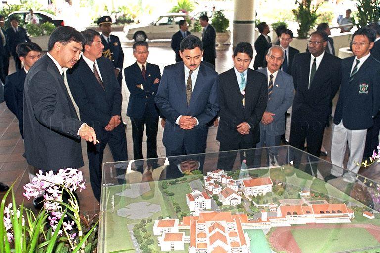 Headmaster of Raffles Institution Wong Siew Hoong (left) explaining and showing Crown Prince of Brunei Darussalem HRH Prince Haji Al-Muhtadee Billah (centre) and Prince Abdul Qawi (left of Prince Billah) a model of Raffles Institution as Minister for Education and Second Minister for Defence Rear Admiral Teo Chee Hean (behind and left of Mr Wong), Singapore's High Commissioner to Brunei Tee Tua Bah (behind and left of Rear Admiral Teo) and rest of delegation look on
