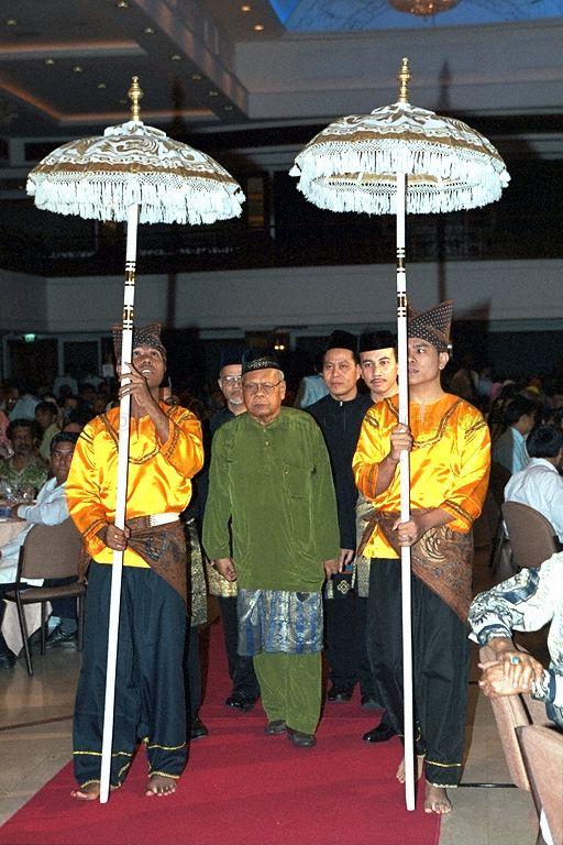 Malay language expert Muhammad Ariff Ahmad (in olive green) being escorted onstage to receive Anugerah Pendeta award from Majlis Pusat during the organisation's thirtieth anniversary dinner at Orchid Country Club; the award is conferred by guest of honour Prime Minister Goh Chok Tong