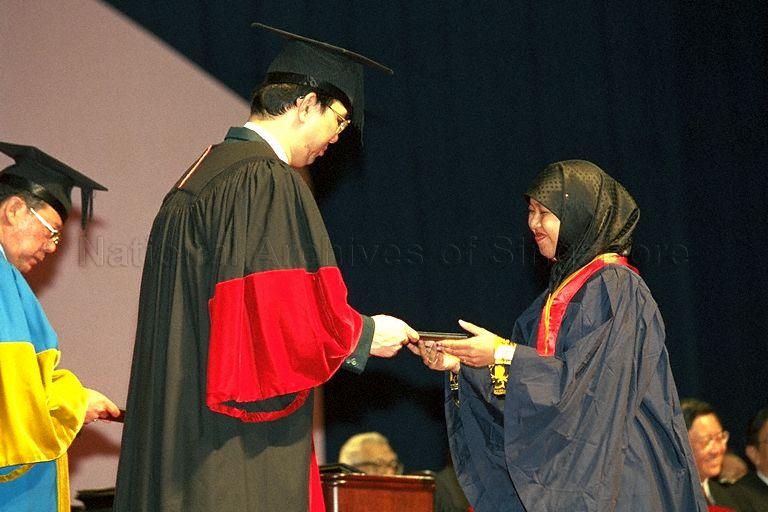 Newly-qualified teacher receiving her National Institute of Education (NIE) diploma from Permanent Secretary, Ministry of Education Chiang Chie Foo (left) at the National Institute of Education Teachers' Investiture Ceremony at the Singapore Indoor Stadium. Minister for Education and Second Minister for Defence Rear Admiral Teo Chee Hean is the guest of honour at this event.