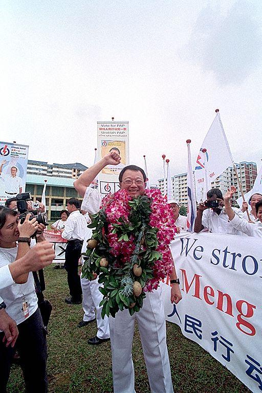 People's Action Party (PAP) candidate for Hougang Constituency Eric Low Siak Meng at White Sands Primary School (Nomination Centre for Hougang Constituency and Pasir Ris-Punggol Group Representation Constituency) on General Elections 2001 Nomination Day. The brown fruits in his garland are chikus; Mr Low had previously compared opposition-held Hougang to a soon-to-be ripe chiku fruit.