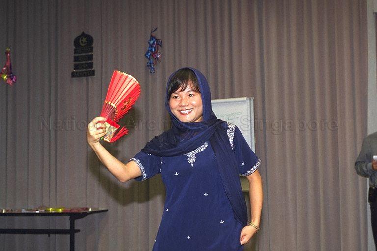 Lady in Indian dress holding Chinese fan at Gongxi Raya Celebration at Government Press Centre, Ministry of Information and the Arts, Port of Singapore Authority (PSA) Building. In 2000, Hari Raya Puasa was on 8 Jan and Chinese New Year was on 5 Feb.