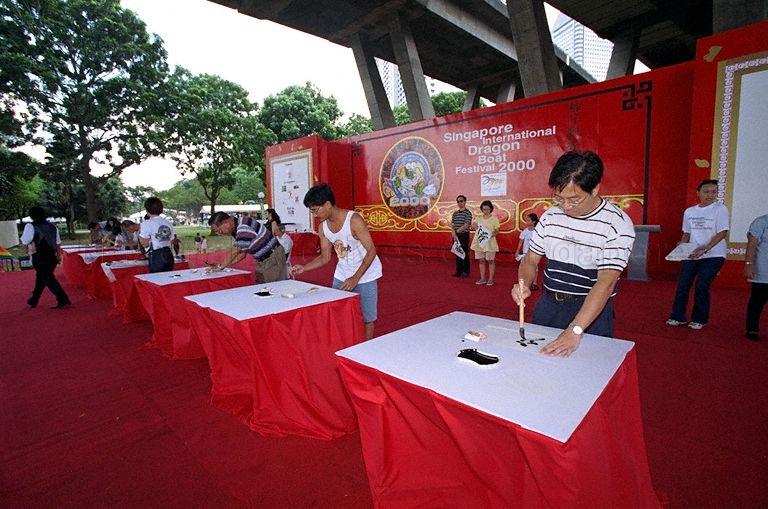 Contestants taking part in Chinese calligraphy contest which is part of the Singapore International Dragon Boat Festival 2000 at Marina Promenade. Promote Mandarin Council Chairman Professor Wee Chow Hou gives away the prizes at this event.
