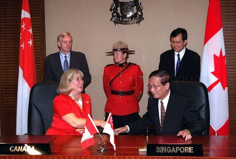 Singapore and Canadian officials exchanging a handshake after signing ceremony of Singapore-Canada Third Country Training Programme at Ministry of Foreign Affairs. Canada is represented by Canadian High Commissioner Doreen Steidle. Looking on are Minister of State for Foreign Affairs and Trade and Industry Raymond Lim Siang Keat and Canadian Secretary of State (Asia-Pacific) David Kilgour