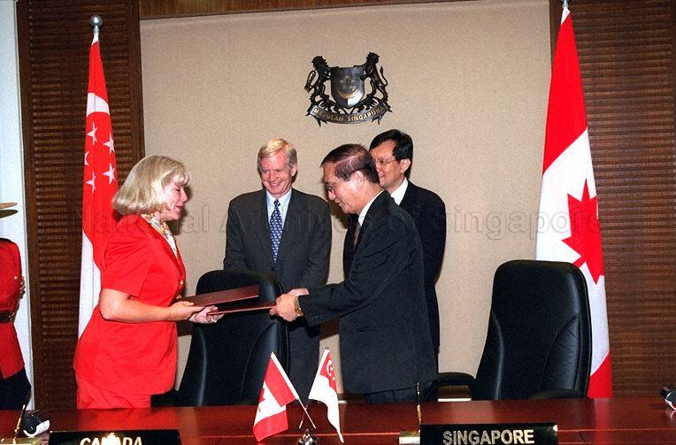 Singapore and Canadian officials exchanging the agreements after signing ceremony of Singapore-Canada Third Country Training Programme at Ministry of Foreign Affairs. Canada is represented by Canadian High Commissioner Doreen Steidle. Looking on are Minister of State for Foreign Affairs and Trade and Industry Raymond Lim Siang Keat (partially hidden) and Canadian Secretary of State (Asia-Pacific) David Kilgour