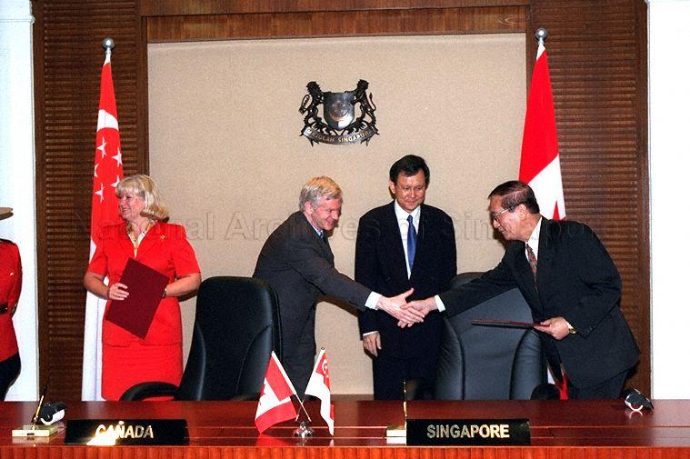 Canadian Secretary of State (Asia-Pacific) David Kilgour and Singapore official exchanging a handshake after signing ceremony of Singapore-Canada Third Country Training Programme at Ministry of Foreign Affairs. Looking on is Minister of State for Foreign Affairs and Trade and Industry Raymond Lim Siang Keat. Canada is represented by Canadian High Commissioner Doreen Steidle