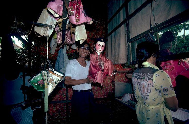 Backstage - Puppeteer raising puppet clad in pink to pose for the camera