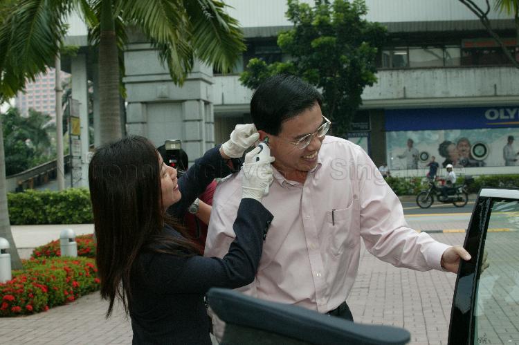 Member of Parliament for Holland-Bukit Panjang Group Representation Constituency (GRC) Dr Teo Ho Pin having his temperature taken at Parliament House