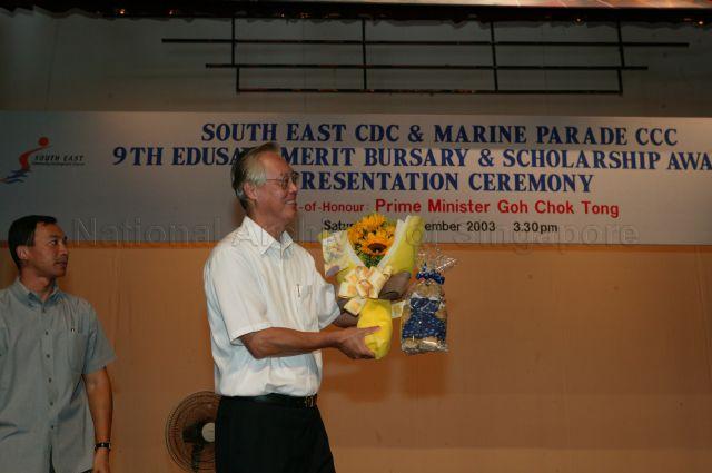 Prime Minister Goh Chok Tong with the bouquet of flowers and token of appreciation presented by student from CHIJ Katong Convent during South East Community Development Council and Marine Parade Citizens' Consultative Committee 9th Edusave Merit Bursary and Scholarship Awards Presentation Ceremony held at the school.