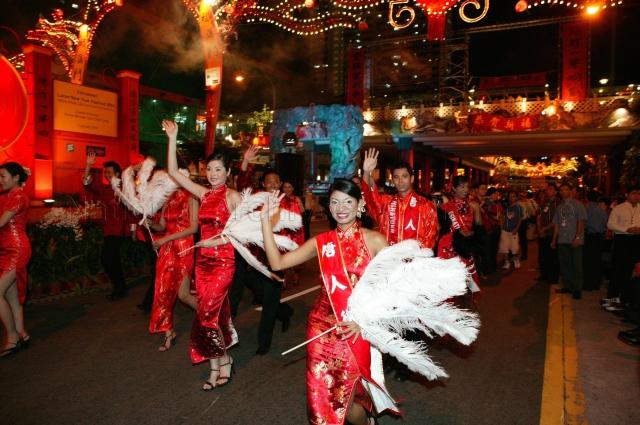 Ladies in red cheongsam and men in mandarin jackets who are part of parade at Lunar New Year Festival 2004 Official Opening and Light-up of Chinatown at New Bridge Road attended by Guest-of-Honour Prime Minister Goh Chok Tong