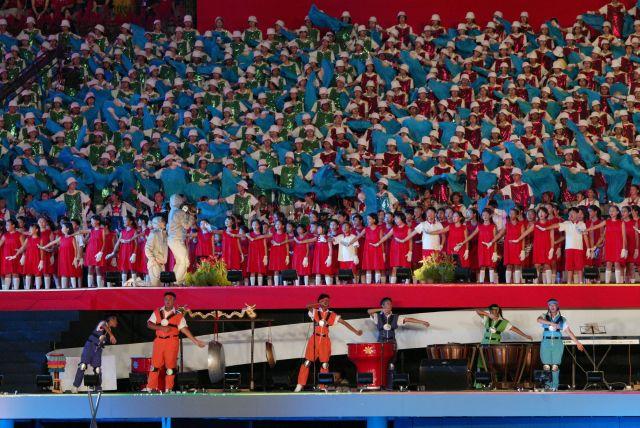 National Day Parade 2004 at the National Stadium -- The Young Voices (in red), a 182-stong choral group from Tampines Primary School and Tanjong Katong Girls' School, performing with combined schools choir at grand finale. At bottom of stage are some of the student percussionists who play 39 different instruments.