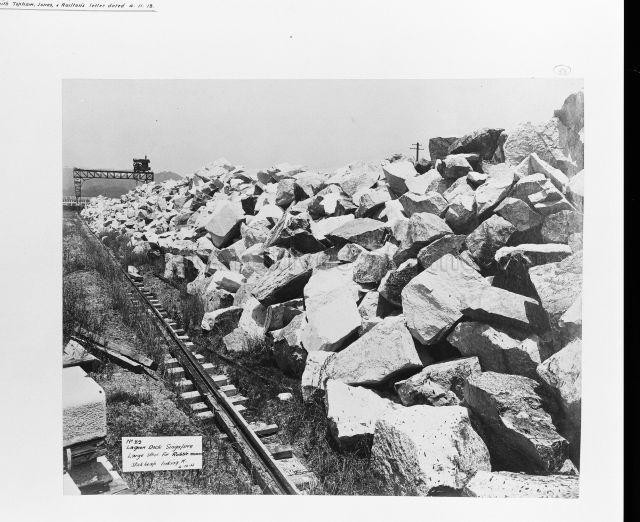 Lagoon dock Singapore - large stones in a heap looking West with crane in the far distance