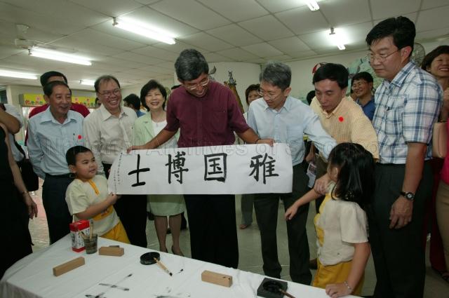 Minister for the Environment and Water Resources Associate Professor Dr Yaacob Ibrahim holding up poster with his name in Chinese calligraphy done by children from People's Action Party Community Foundation (PCF) Queenstown Sparkletots Child Care Centre during community visit to Queenstown Division of Tanjong Pagar Group Representation Constituency (GRC). Looking on are Members of Parliament for Tanjong Pagar GRC Chay Wai Chuen (right) and Associate Professor Koo Tsai Kee who is also Senior Parliamentary Secretary for Defence and the Environment and Water Resources.