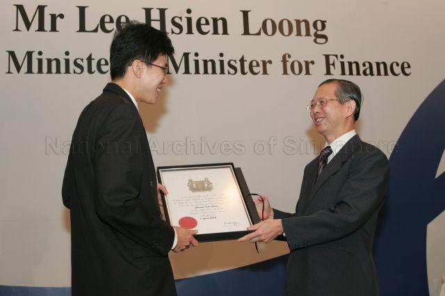 Permanent Secretary to Ministry of Finance and outgoing Head of Civil Service Lim Siong Guan presenting certificate of appointment/promotion to Director, Economics Division, Ministry of Trade and Industry, Cheang Kok Chung during annual dinner for the Administrative Service, the Civil Service's elite wing, at Conrad Centennial Singapore. Guest of Honour at the dinner was Prime Minister and Minister for Finance Lee Hsien Loong.
