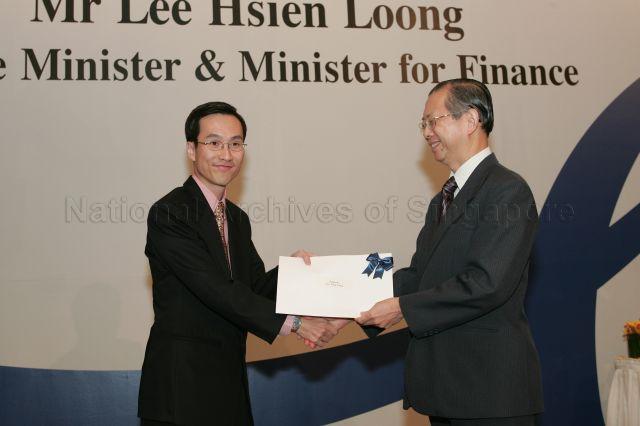 Permanent Secretary to Ministry of Finance and outgoing Head of Civil Service Lim Siong Guan presenting certificate of appointment/promotion to Director, Industry Division, Ministry of Trade and Industry, Augustin Lee Tong Yang during annual dinner for the Administrative Service, the Civil Service's elite wing, at Conrad Centennial Singapore. Guest of Honour at the dinner was Prime Minister and Minister for Finance Lee Hsien Loong.
