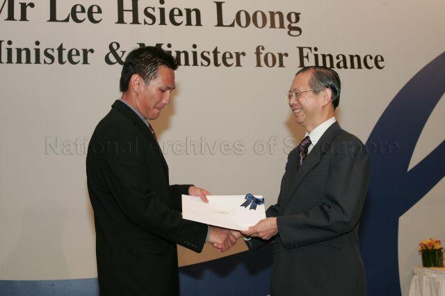 Permanent Secretary to Ministry of Finance and outgoing Head of Civil Service Lim Siong Guan presenting certificate of appointment/promotion to Director, Fiscal Policy Directorate, Ministry of Finance, Donald Low How Tian during annual dinner for the Administrative Service, the Civil Service's elite wing, at Conrad Centennial Singapore. Guest of Honour at the dinner was Prime Minister and Minister for Finance Lee Hsien Loong.