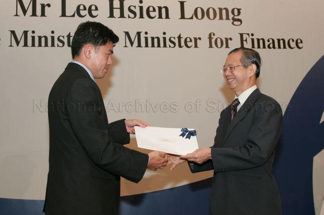 Permanent Secretary to Ministry of Finance and outgoing Head of Civil Service Lim Siong Guan presenting certificate of appointment/promotion to Deputy Director of Healthcare Infrastructure and Delivery Branch, Ministry of Health, Gabriel Lim Meng Liang during annual dinner for the Administrative Service, the Civil Service's elite wing, at Conrad Centennial Singapore. Guest of Honour at the dinner was Prime Minister and Minister for Finance Lee Hsien Loong.