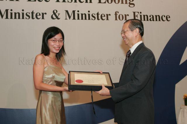 Permanent Secretary to Ministry of Finance and outgoing Head of Civil Service Lim Siong Guan presenting certificate of appointment/promotion to Assistant Director (Management Information/Planning), Ministry of Education, Ms Lee Shiao Wei during annual dinner for the Administrative Service, the Civil Service's elite wing, at Conrad Centennial Singapore. Guest of Honour at the dinner was Prime Minister and Minister for Finance Lee Hsien Loong.