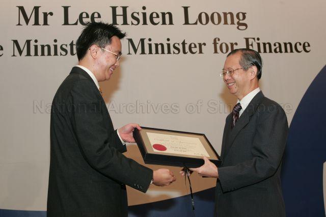 Permanent Secretary to Ministry of Finance and outgoing Head of Civil Service Lim Siong Guan presenting certificate of appointment/promotion to Senior Officer, Oil and Gas, Economic Development Board, Eugene Leong Chee Gin during annual dinner for the Administrative Service, the Civil Service's elite wing, at Conrad Centennial Singapore. Guest of Honour at the dinner was Prime Minister and Minister for Finance Lee Hsien Loong.