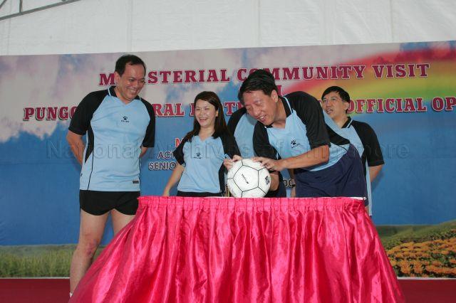 From left, Member of Parliament (MP) for Pasir Ris-Punggol Group Representation Constituency (GRC) Charles Chong, Miss Penny Low and Dr Michael Lim (right) during Acting Second Minister for Finance and Senior Minister of State for Foreign Affairs Raymond Lim's (centre, hidden) community visit to Punggol Central cum official opening of Punggol Central football field while Minister for Defence Teo Chee Hean autographs on the football