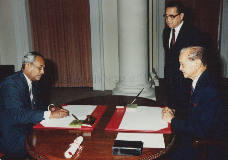 Judicial Commissioner M Karthigesu signing the affirmation of office during his swearing-in as Supreme Court judge in the presence of President Wee Kim Wee and Chief Justice Yong Pung How (second from right) at Istana