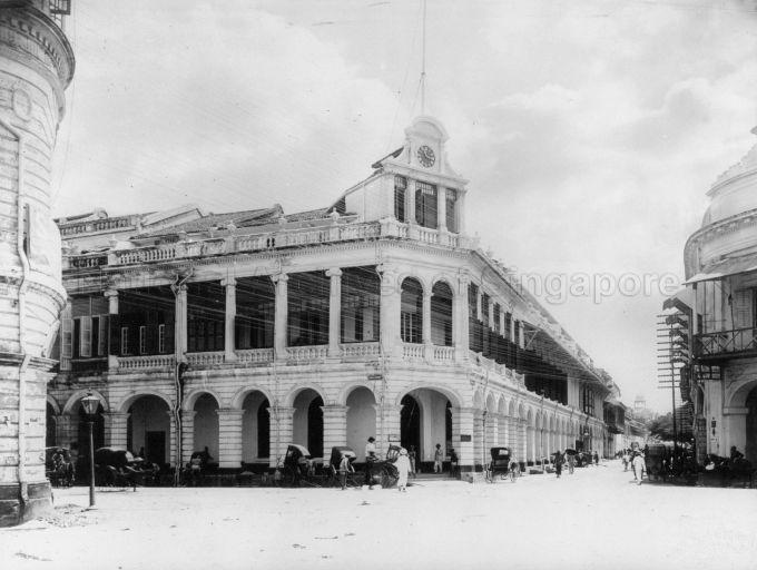Corner of Cecil Street and D'Almeida Street, featuring the building formerly occupied by the Whiteaway Laidlaw department store and later, the Netherlands Trading Society, Singapore. This photograph was probably taken in between the two occupations, showing a new clock "tower" installed.