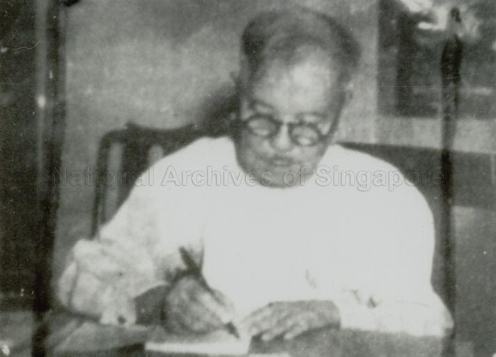 Photograph of Tan Kah Kee penning a letter