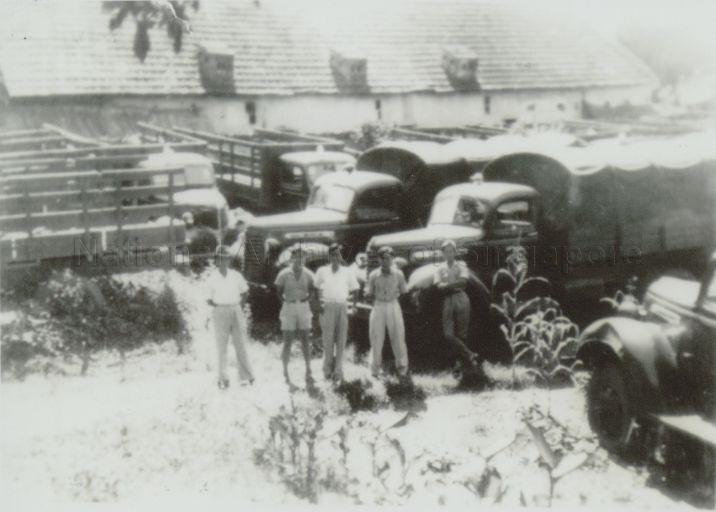 Chinese volunteer mechanic drivers posing in front of their trucks. One of the tasks of the Nanyang Chinese volunteer drivers and mechanics was to take delivery of vehicles. Zhuang Linzu (second from right) and Lin Xinquan (second from left) were receiving US Dodge vehicles at Haiphong, Vietnam
