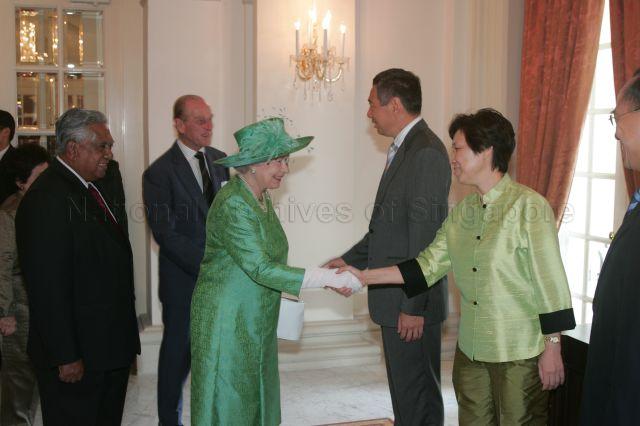 Queen Elizabeth II, accompanied by President S R Nathan, being greeted by Prime Minister (PM) Lee Hsien Loong's wife, Ho Ching, at Istana after the ceremonial welcome. Meanwhile, PM Lee greets the Duke of Edinburgh Prince Philip.