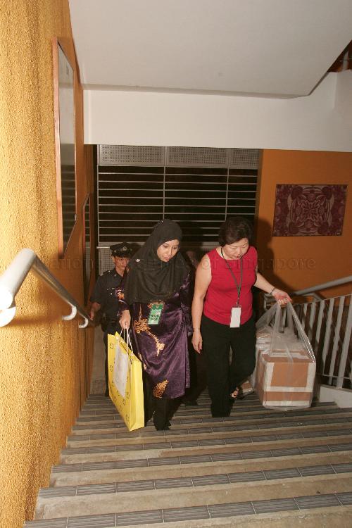 Presiding Officer delivering sealed ballot boxes to counting centre after the close of the poll at Bedok View Secondary School during Singapore General Election