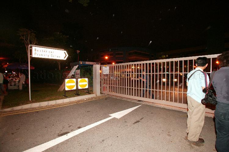 Police officer closing gate of Bendemeer Primary School, the counting centre for Potong Pasir during Singapore General Election