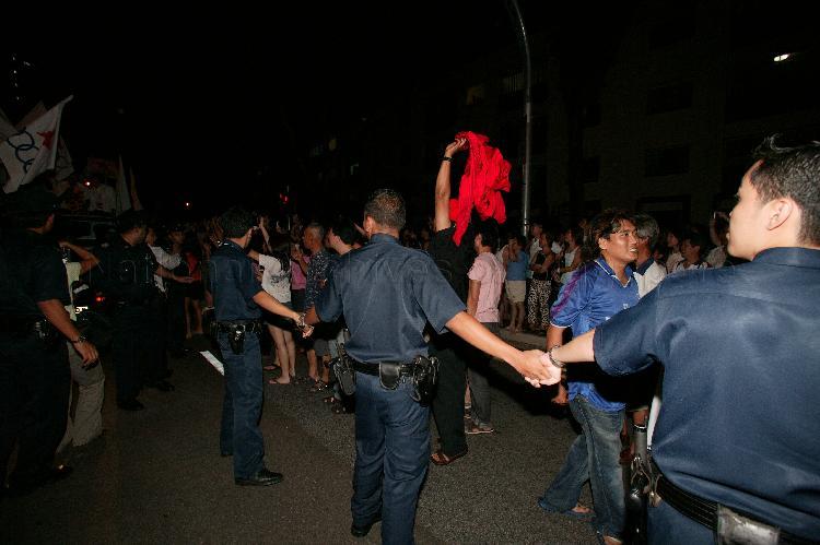 Police officers controlling crowd of Singapore Democratic Alliance (SDA) supporters in the street at Potong Pasir during Singapore General Election