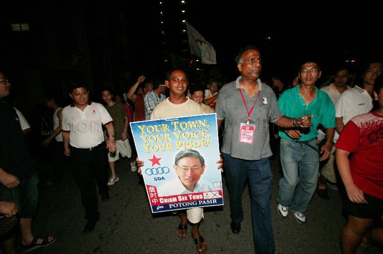 Singapore Democratic Alliance (SDA) supporters with campaign poster of SDA candidate for Potong Pasir Chiam See Tong in the street during Singapore General Election
