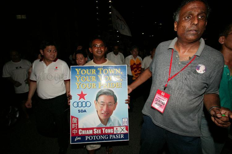 Singapore Democratic Alliance (SDA) supporters with campaign poster of SDA candidate for Potong Pasir Chiam See Tong in the street during Singapore General Election