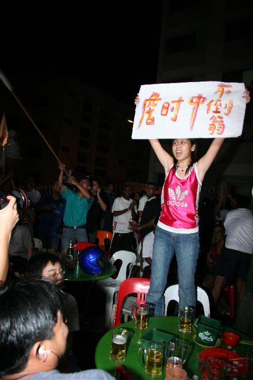Supporter of Singapore Democratic Alliance (SDA) candidate for Potong Pasir Chiam See Tong holding up a handwritten poster outside Jin Biao Coffeeshop at Block 136, Potong Pasir Avenue 3. The coffeeshop was assembly centre for SDA and their supporters while waiting for election results during Singapore General Election.