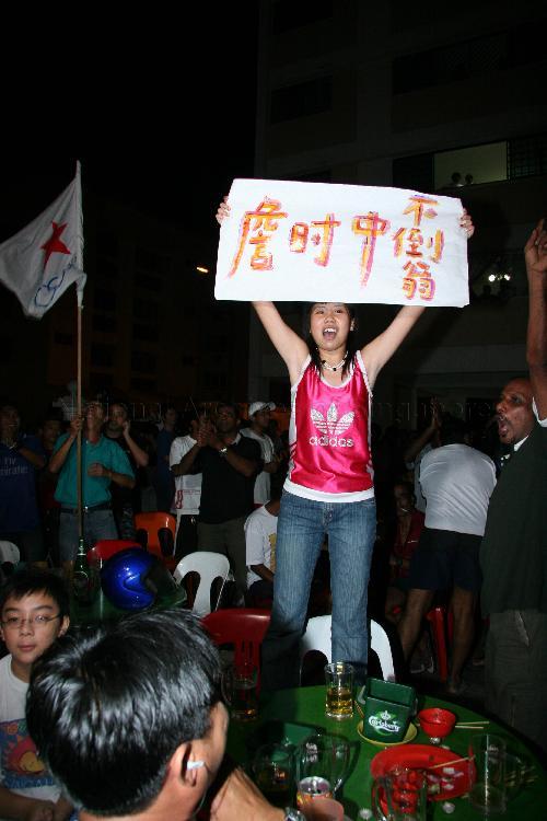 Supporter of Singapore Democratic Alliance (SDA) candidate for Potong Pasir Chiam See Tong holding up a handwritten poster outside Jin Biao Coffeeshop at Block 136, Potong Pasir Avenue 3. The coffeeshop was assembly centre for SDA and their supporters while waiting for election results during Singapore General Election.