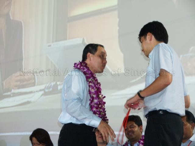 Workers' Party (WP) candidate for Hougang Low Thia Khiang (garlanded) having a conversation with WP candidate for East Coast Group Representation Constituency (GRC) Brandon Siow Wei Min on the stage at Yio Chu Kang stadium, the assembly centre for WP and their supporters during Singapore General Election