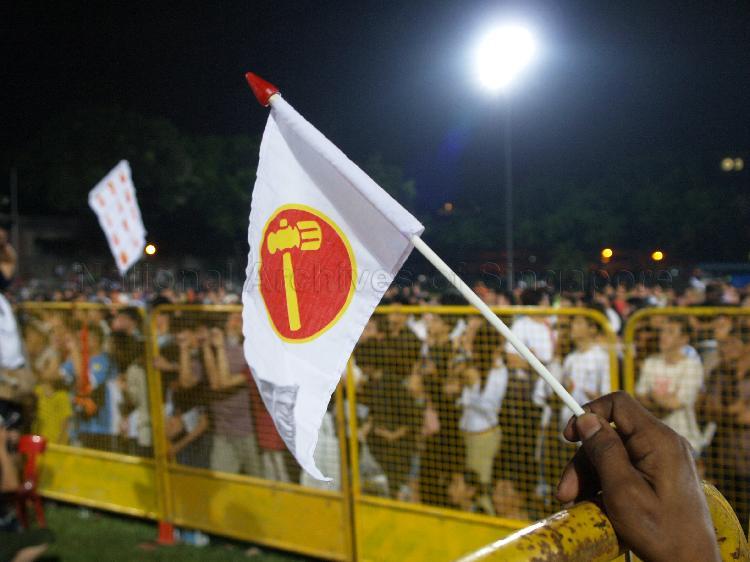 View of Workers' Party (WP) flag being held by a supporter at Yio Chu Kang stadium, the assembly centre for WP and their supporters while waiting for election results during Singapore General Election