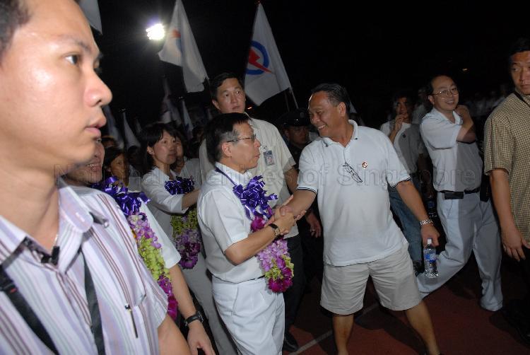 People's Action Party (PAP) candidate for Tampines Group Representation Constituency (GRC) Mah Bow Tan (garlanded) being greeted by supporter at Serangoon stadium, the assembly centre for PAP and their supporters during Singapore General Election. Behind him is Ms Irene Ng Phek Hoong (garlanded), one of PAP candidates for Tampines GRC.