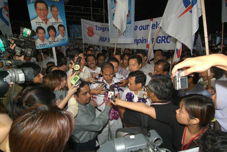 People's Action Party (PAP) candidate for Tampines Group Representation Constituency (GRC) Masagos Zulkifli bin Masagos Mohamad speaking to the media while his GRC team members (garlanded) look on at Serangoon stadium after their victory during Singapore General Election. The stadium was assembly centre for PAP and their supporters.