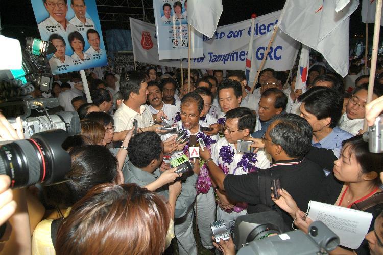 People's Action Party (PAP) candidate for Tampines Group Representation Constituency (GRC) Masagos Zulkifli bin Masagos Mohamad speaking to the media while his GRC team members (garlanded) look on at Serangoon stadium after their victory during Singapore General Election. The stadium was assembly centre for PAP and their supporters.