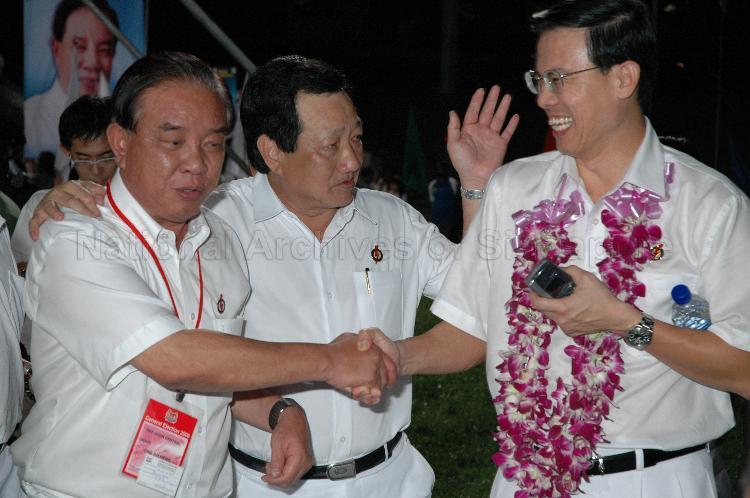 People's Action Party (PAP) candidate for Nee Soon Central Ong Ah Heng (left) and elected PAP Member of Parliament (MP) for Hong Kah Group Representation Constituency (GRC) Ang Mong Seng congratulating PAP candidate for Bukit Panjang Dr Teo Ho Pin (garlanded) on his being elected as MP at Woodlands stadium, the assembly centre for PAP and their supporters during Singapore General Election