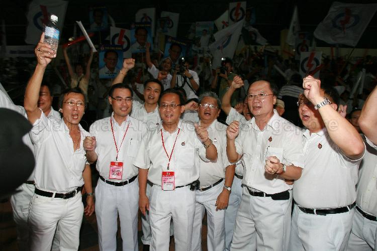 People's Action Party (PAP) candidate for Yio Chu Kang Seng Han Thong (third from left) and PAP members cheering at Woodlands stadium, the assembly centre for PAP and their supporters during Singapore General Election