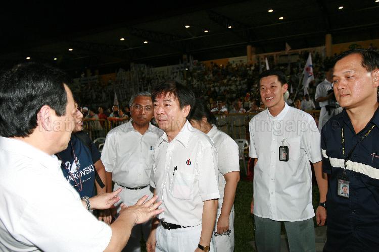 Elected People's Action Party (PAP) Member of Parliament for Hong Kah Group Representation Constituency (GRC) Ang Mong Seng (far left) having a conversation with PAP candidate for Sembawang GRC Khaw Boon Wan at Woodlands stadium, the assembly centre for PAP and their supporters during Singapore General Election