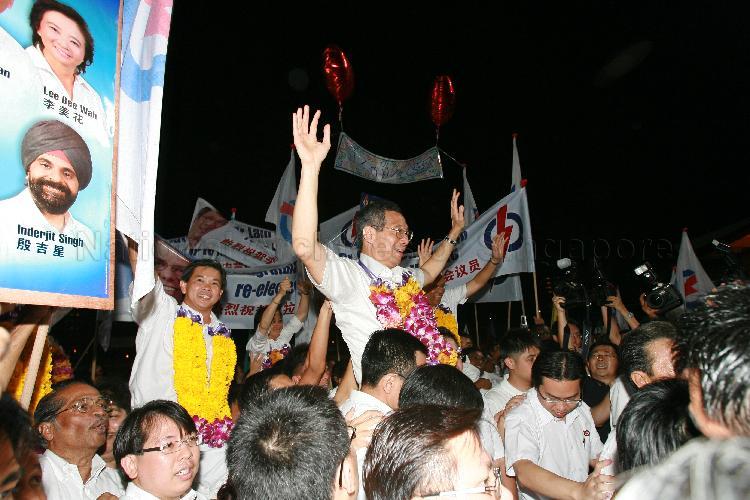People's Action Party (PAP) candidate for Ang Mo Kio Group Representation Constituency (GRC) Lee Hsien Loong (garlanded) and his GRC team members (garlanded) being chaired by supporters at Woodlands stadium after their victory during Singapore General Election. The stadium was assembly centre for PAP and their supporters.