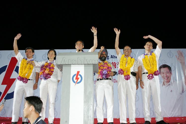 People's Action Party (PAP) candidates for Ang Mo Kio Group Representation Constituency (GRC), from right, Dr Lam Pin Min, Dr Balaji Sadasivan, Inderjit Singh, Lee Hsien Loong, Ms Lee Bee Wah and Wee Siew Kim waving to supporters from the stage at Woodlands stadium after their victory during Singapore General Election. The stadium was assembly centre for PAP and their supporters.