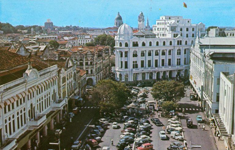 View of Raffles Place with Robinsons department store (left foreground) and Chartered Bank (centre), Singapore
