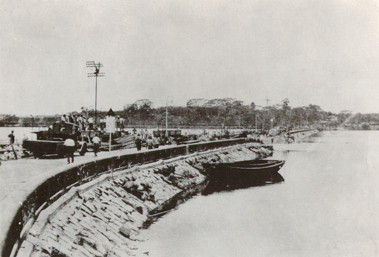 This picture was taken in early 1942 as it shows the breech in the Causeway made on 31st January 1942 by the retreating forces and a temporary bridge was put in place by 18th February 1942.